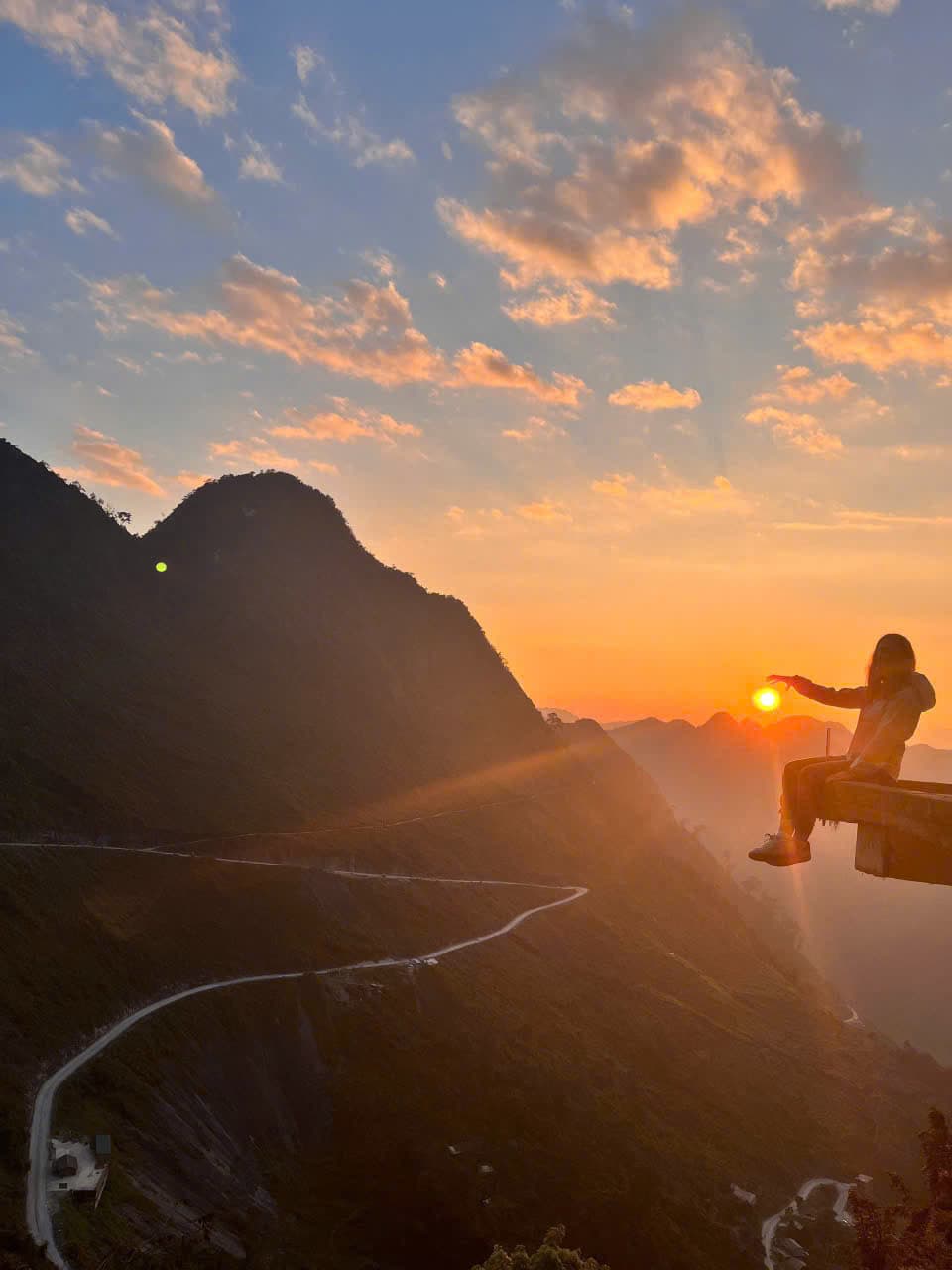Traveler standing at a mountain viewpoint in Ha Giang with Vietnamese flag monument